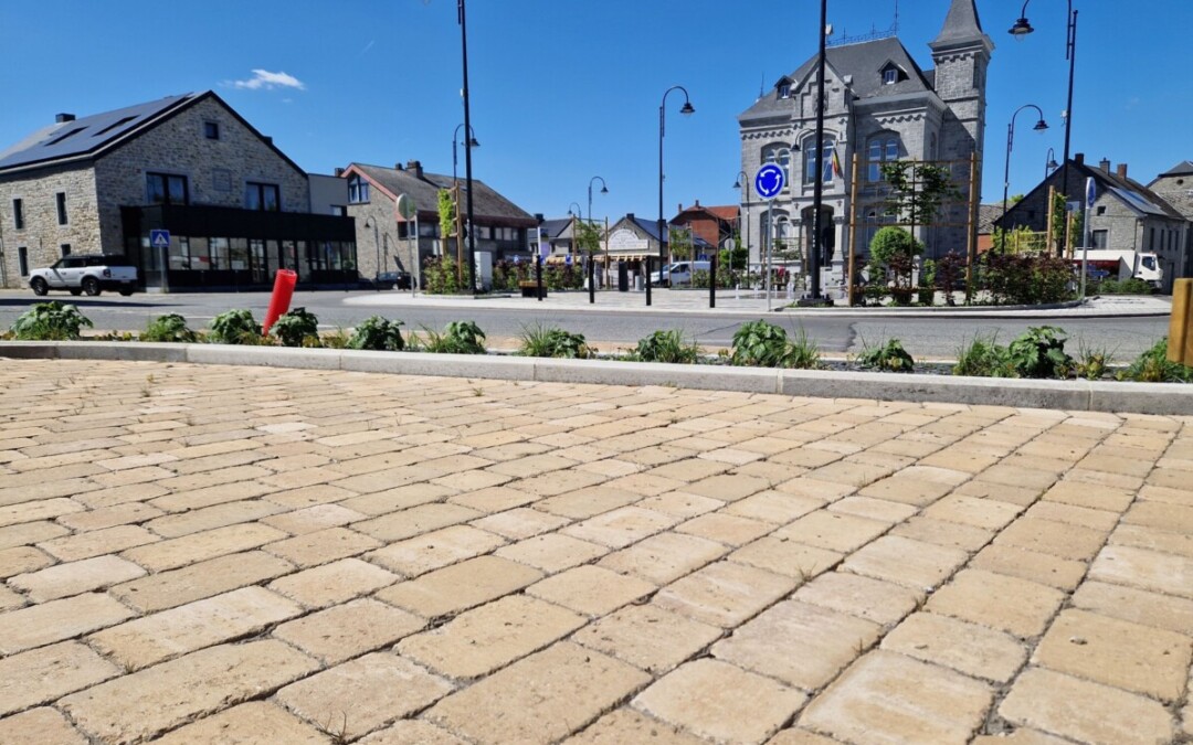 Allée en pavés carrossables carrés et rectangles devant une place de village.