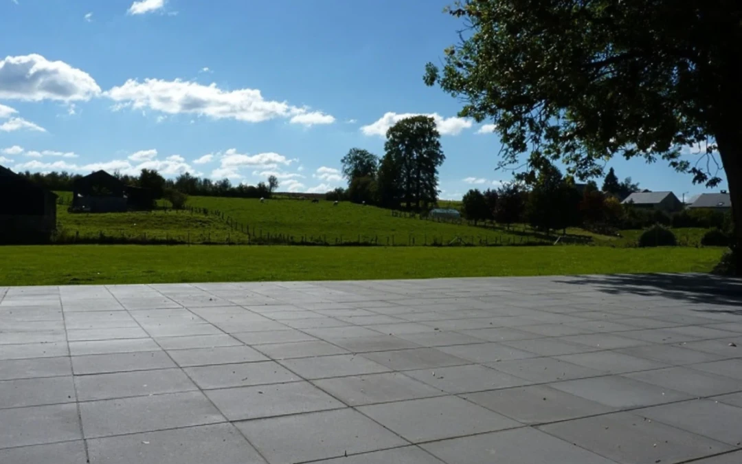 Terrasse en dalles béton bordant un jardin en campagne