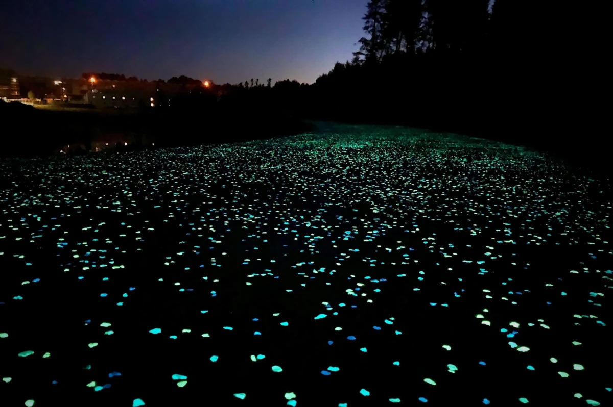 Chemin de nuit dans lequel ont été intégré des granulats luminescents qui restituent la lumière captée durant la journée