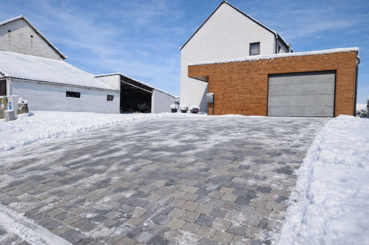 allee-paves-enneigee Allée de pavés gris nuancé enneigée.