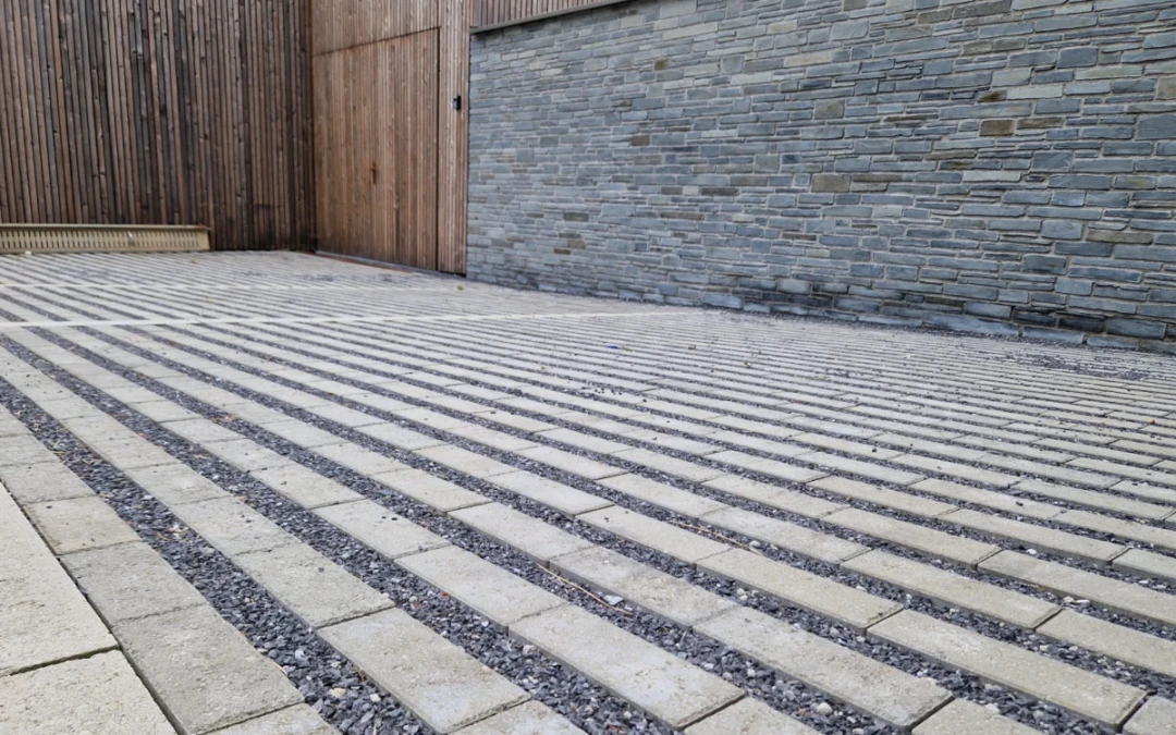 Allée de garage en pavés drainants et graviers pour une meilleure gestion des eaux pluviales dans les espaces privés.