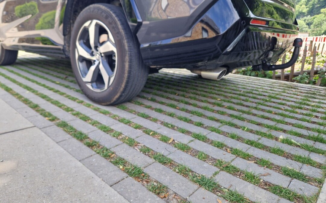 Allée carrossable en pavés drainants gris béton engazonnés.